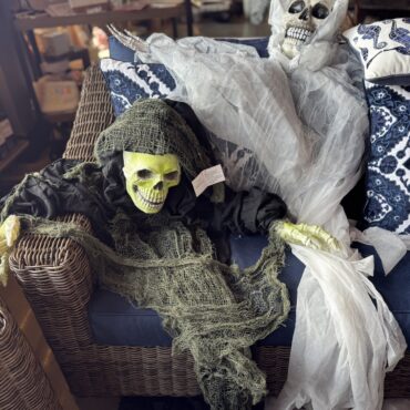 Halloween skeleton and pillows styled in a home decor vignette
