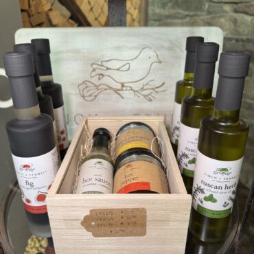 Specialty oils and pantry gifts arranged in a wooden gift box